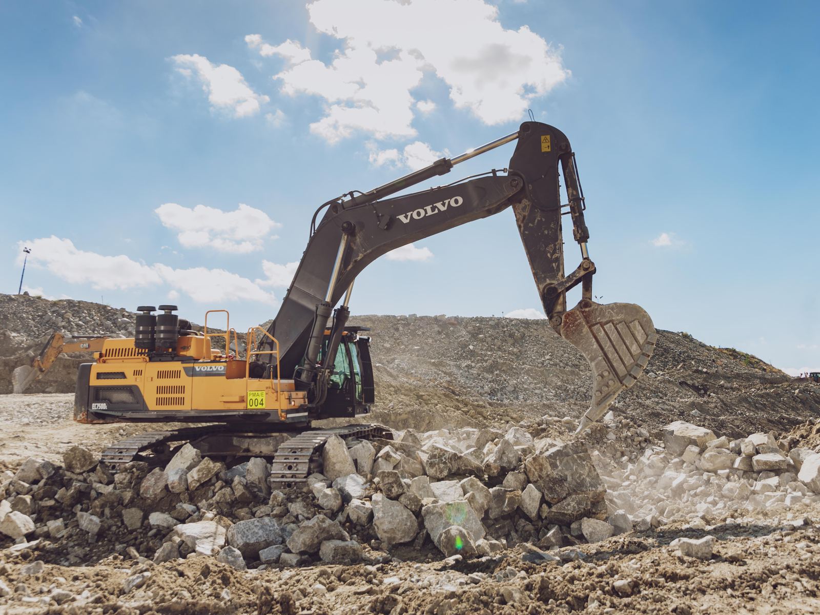 Excavator working a rock face at a Siyanda Resources mining site